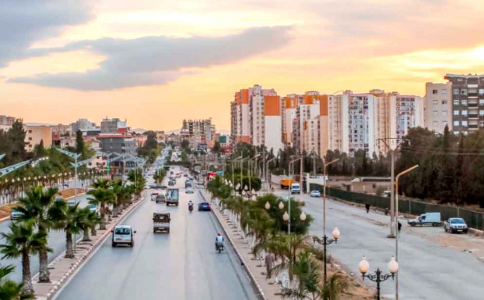 Ouled Yaïch AADL residential buildings with busy street traffic in Blida Province, Algeria