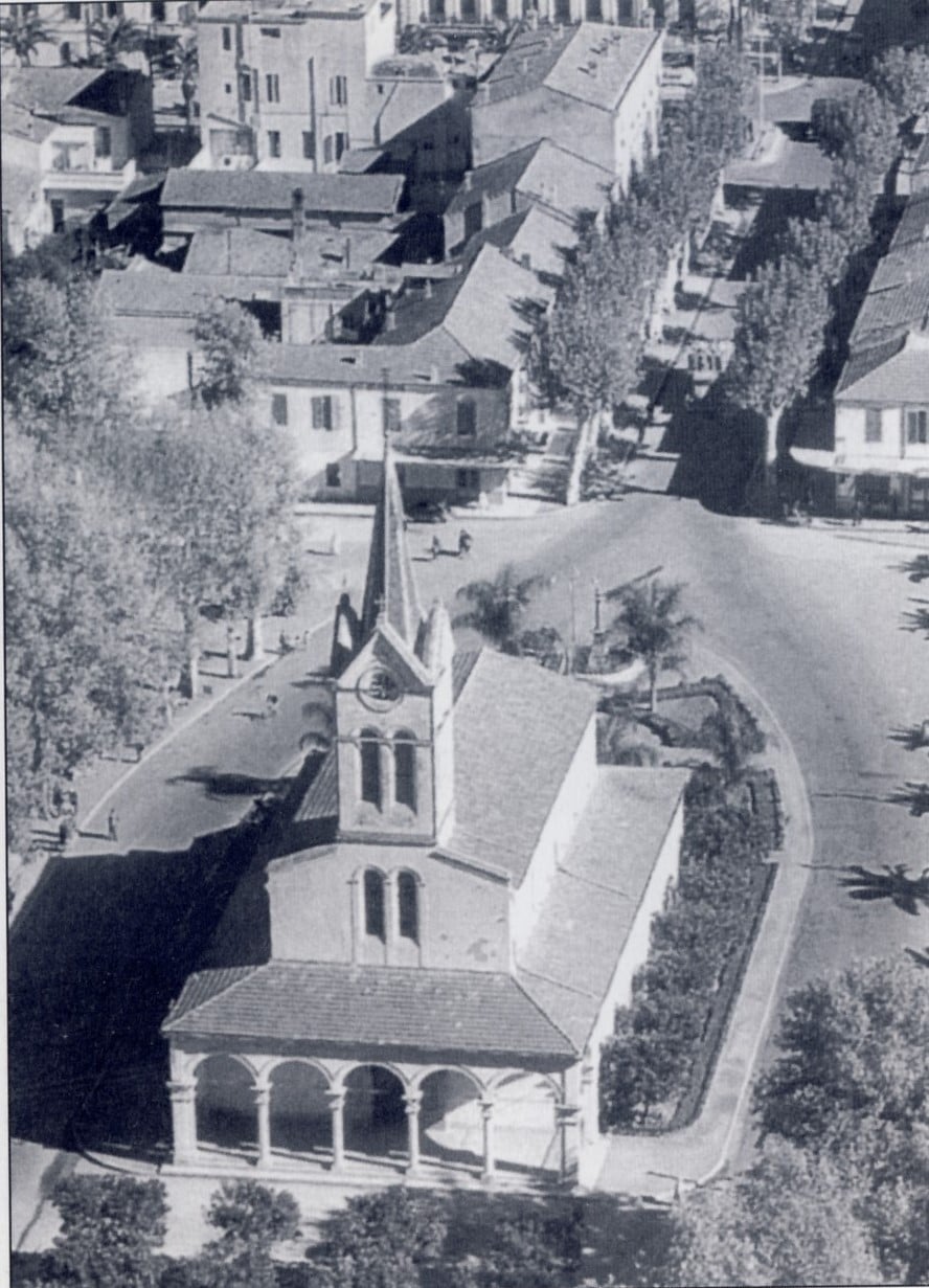 Exterior view of Tassili Church in Boufarik, showing its old stone façade and arched windows.