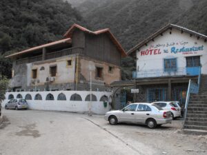 Exterior view of Hotel Ruisseau des Singes in Chréa, surrounded by nature and mountain landscape.